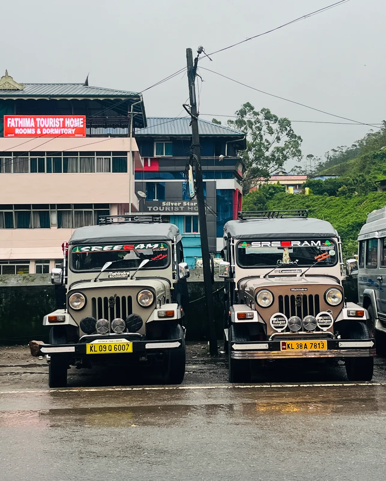 Two Sreeram safari jeeps parked in Munnar town on a rainy morning